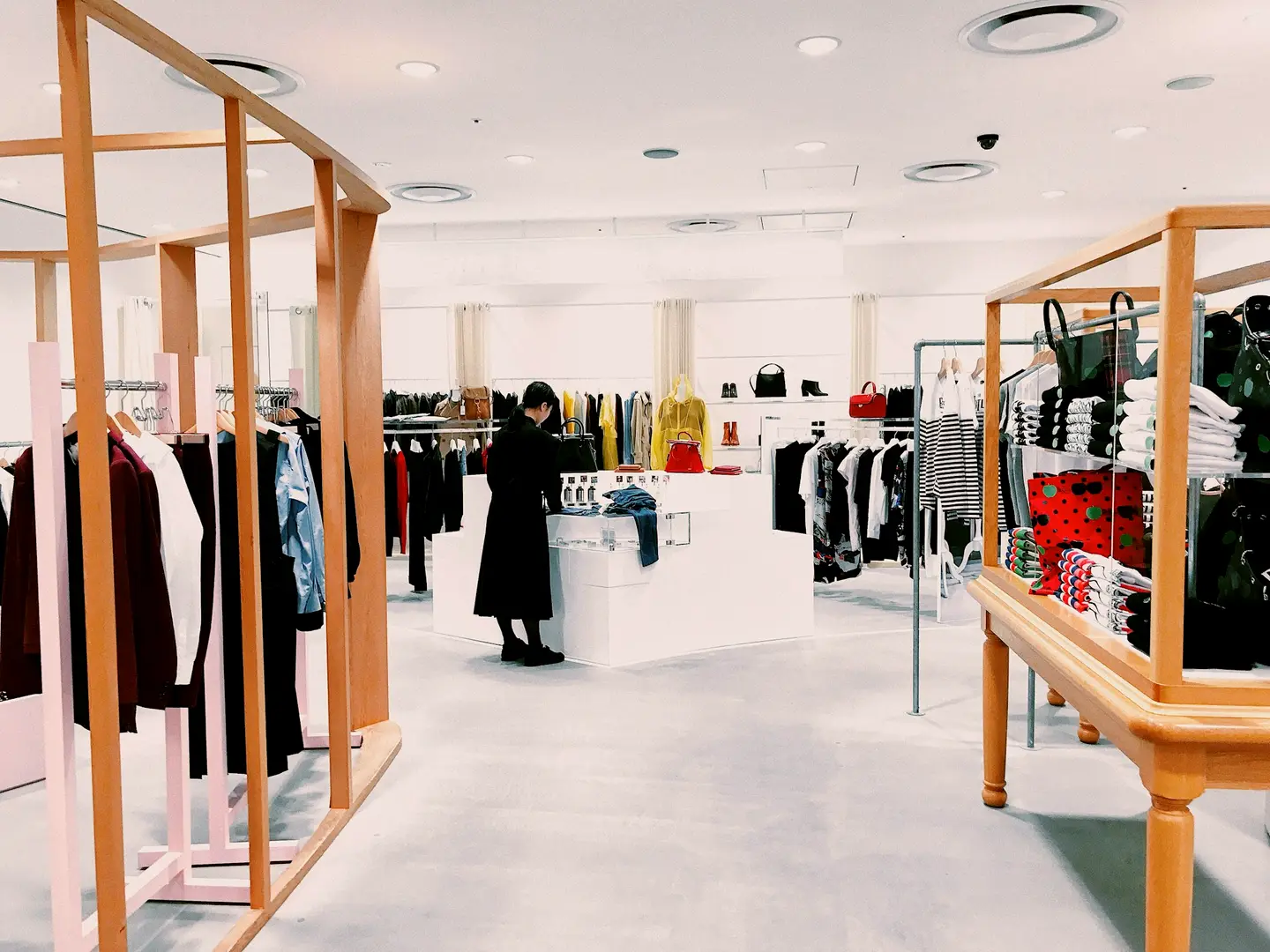 The inside of a bright retail shop, lit by rows of ceiling spots over the displays.